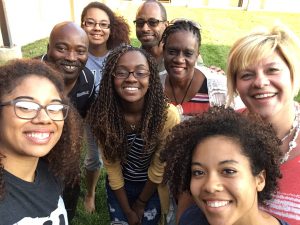 eight people looking up at the camera and smiling